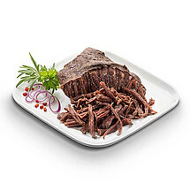 Gegartes Pulled Beef von WestFood, angerichtet auf einem weißen Teller mit etwas Salat zur Verzierung.